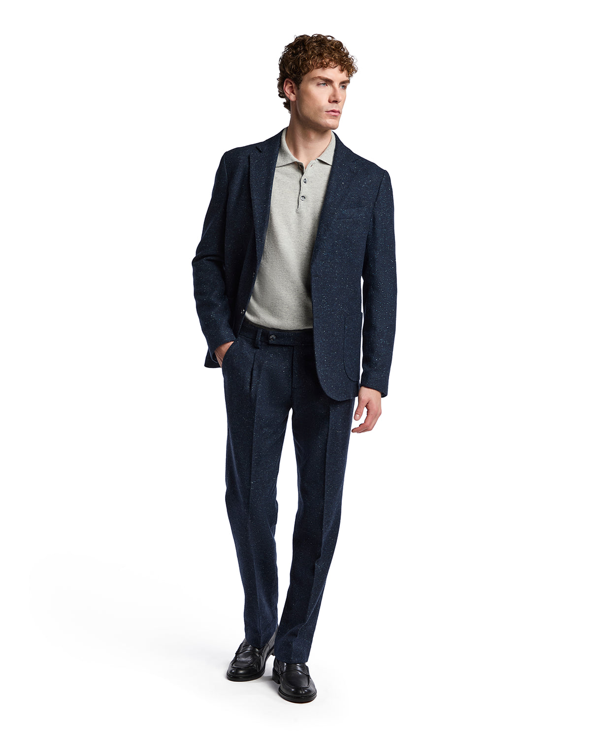 Navy blue tailored suit, textured fabric, paired with a gray polo shirt, sleek modern style for men.