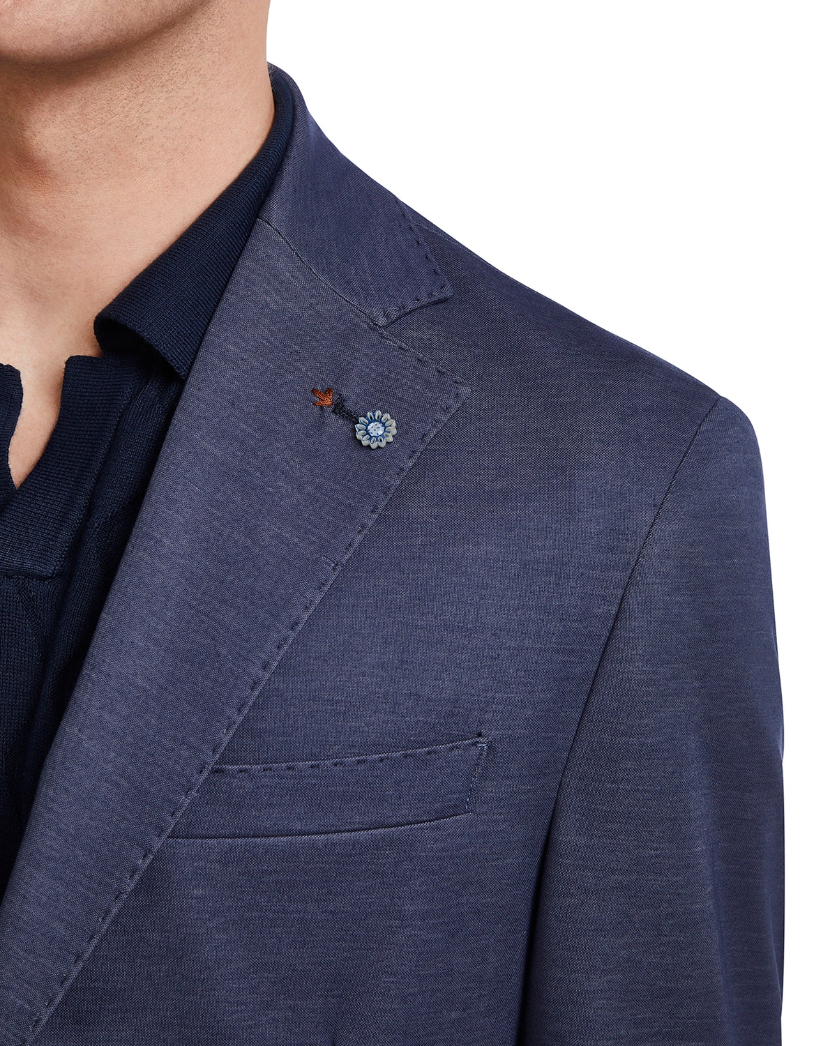 Navy blue men's blazer with a lightweight fabric and floral lapel pin, perfect for stylish casual wear.