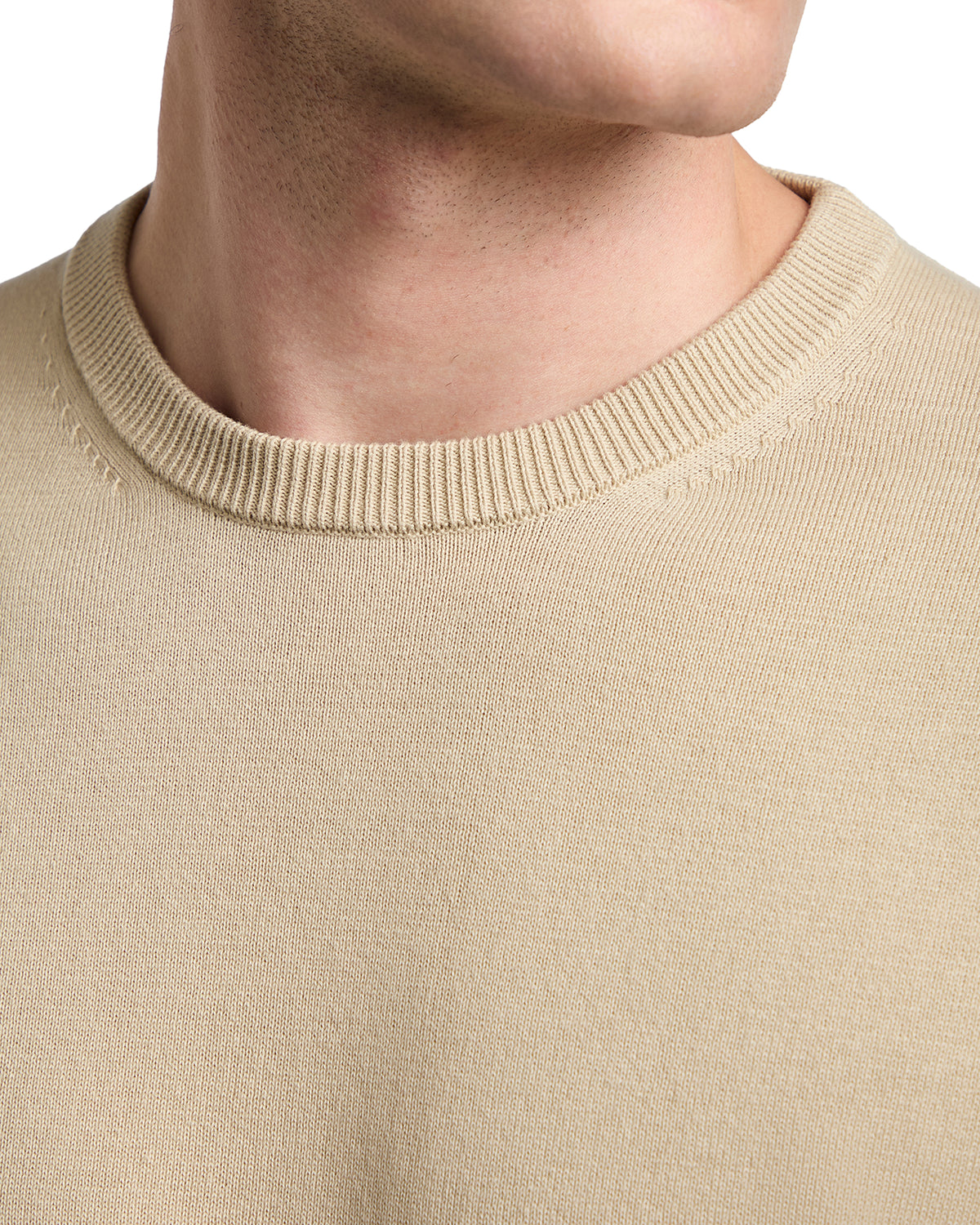 Beige knit sweater with a classic crew neckline, perfect for casual layering in cooler weather.