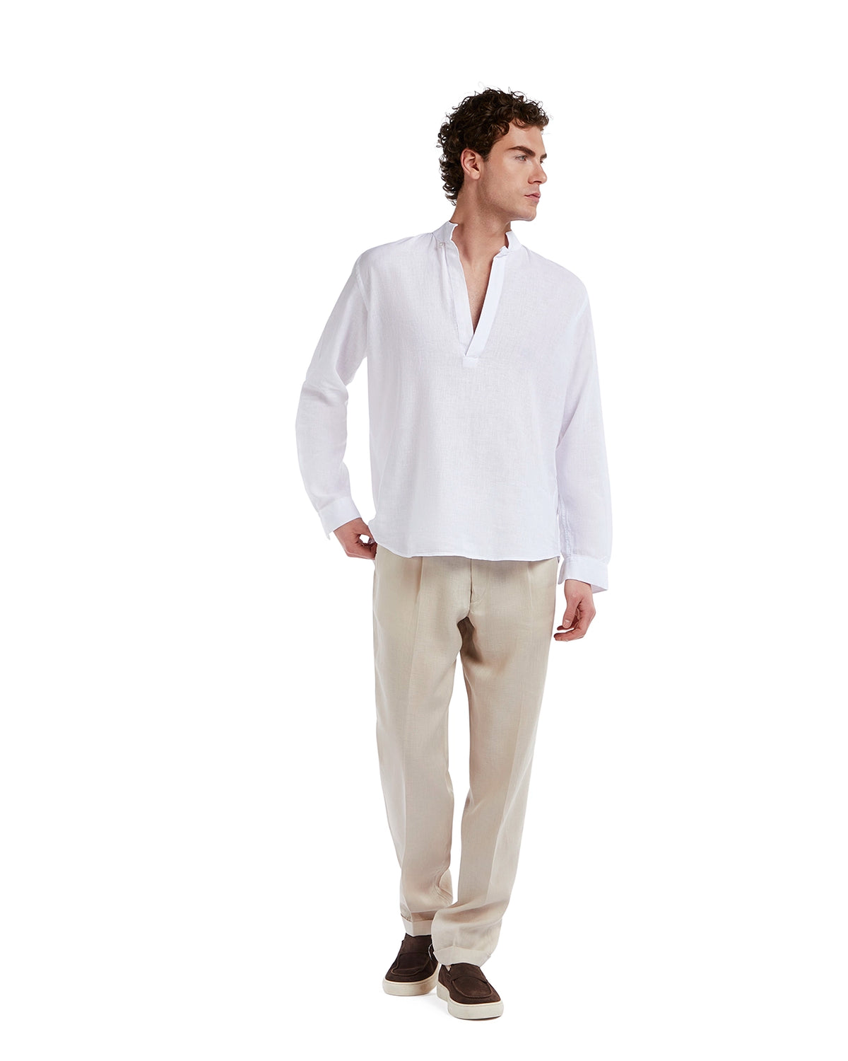 White linen long sleeve shirt with a relaxed fit, paired with beige trousers and casual brown shoes.