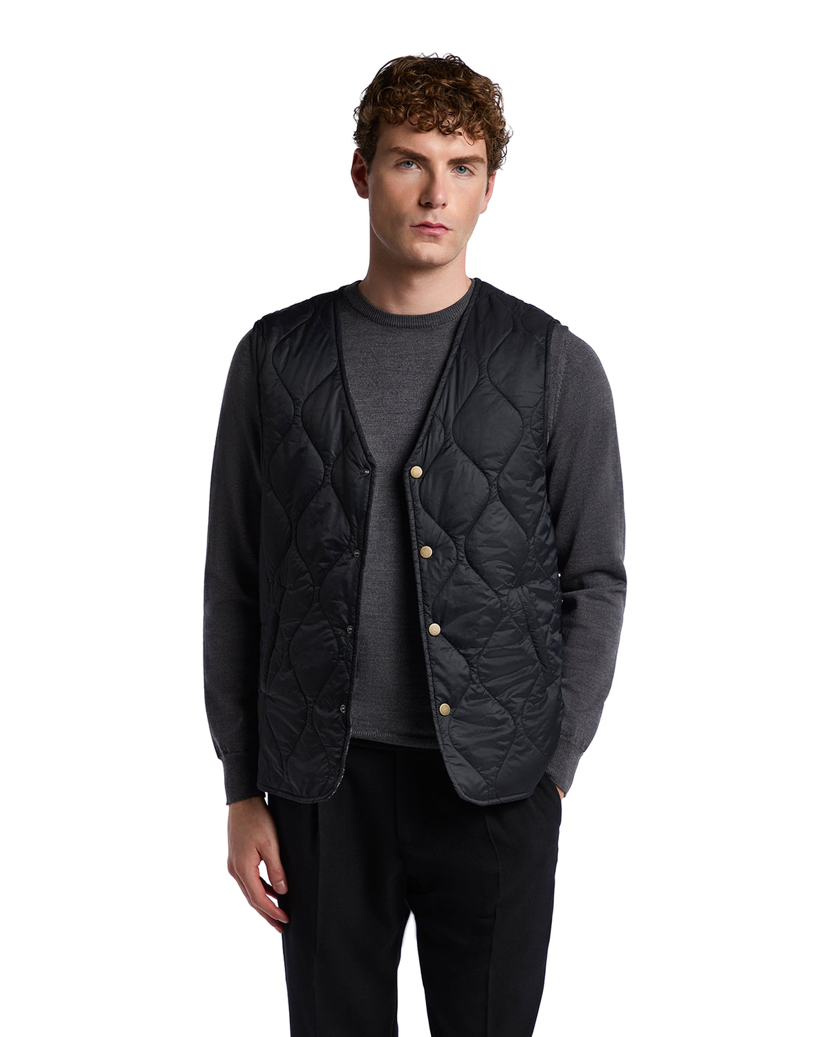 Black quilted vest with button closure, layered over a gray long-sleeve shirt, perfect for stylish layering.