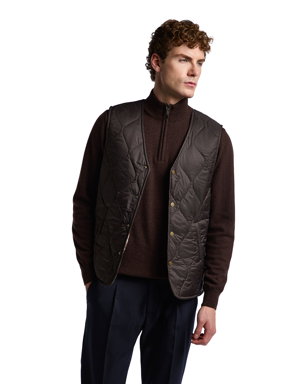 Brown quilted vest made from lightweight nylon, paired with a zip-up dark sweater, ideal for stylish layering.