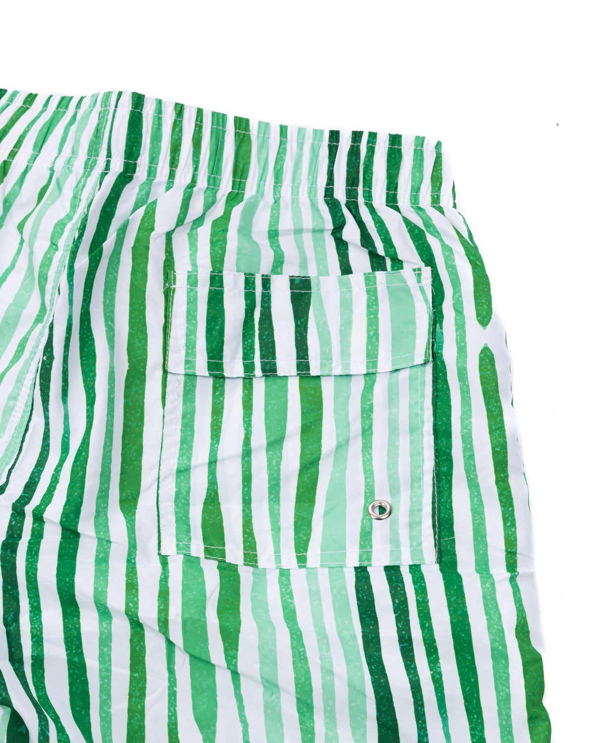Green and white striped swim trunks with elastic waistband and back pocket with metal grommet detail.
