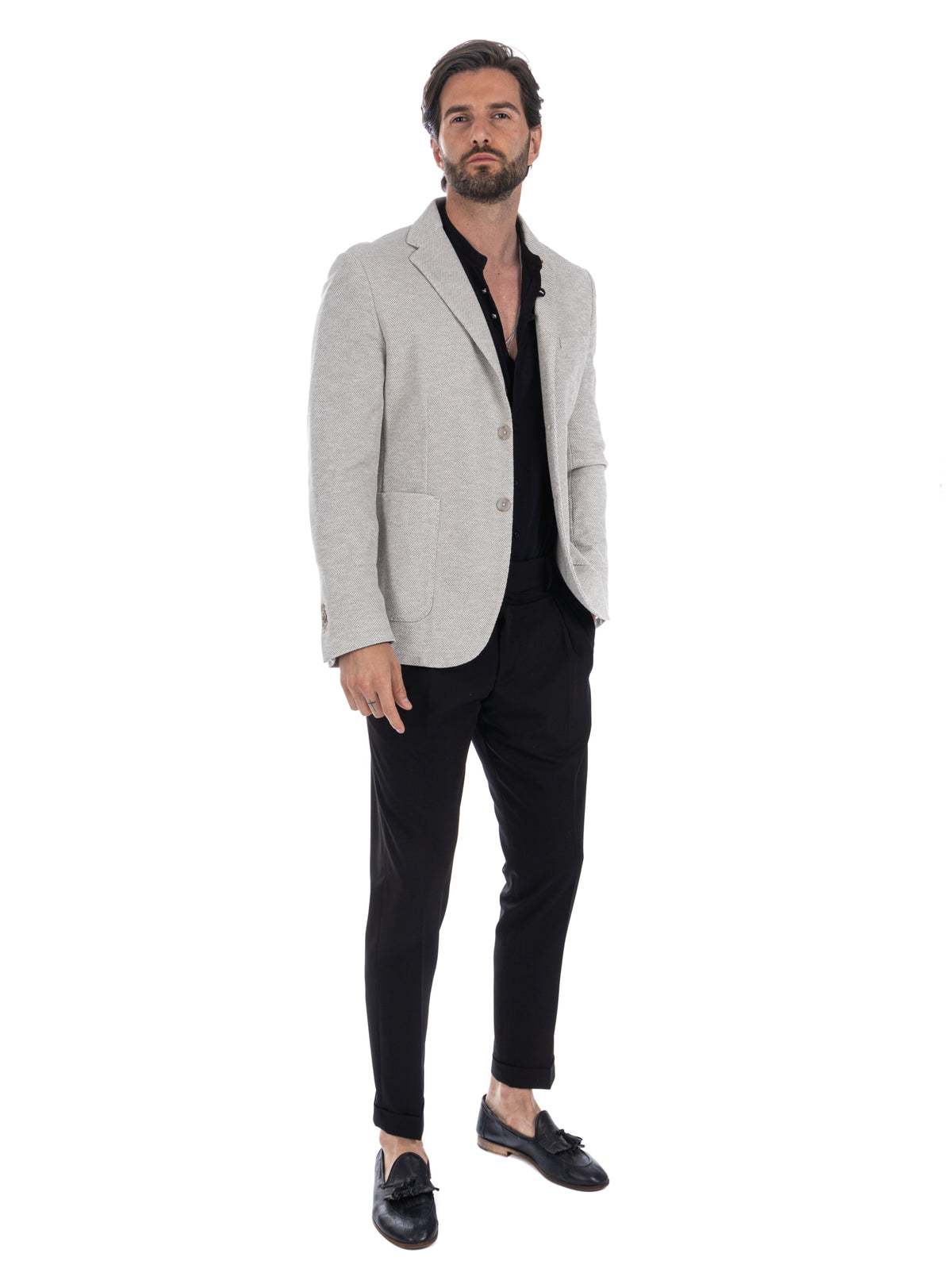 Light gray textured blazer with black shirt, slim trousers, and tassel loafers. Smart casual men's fashion outfit.