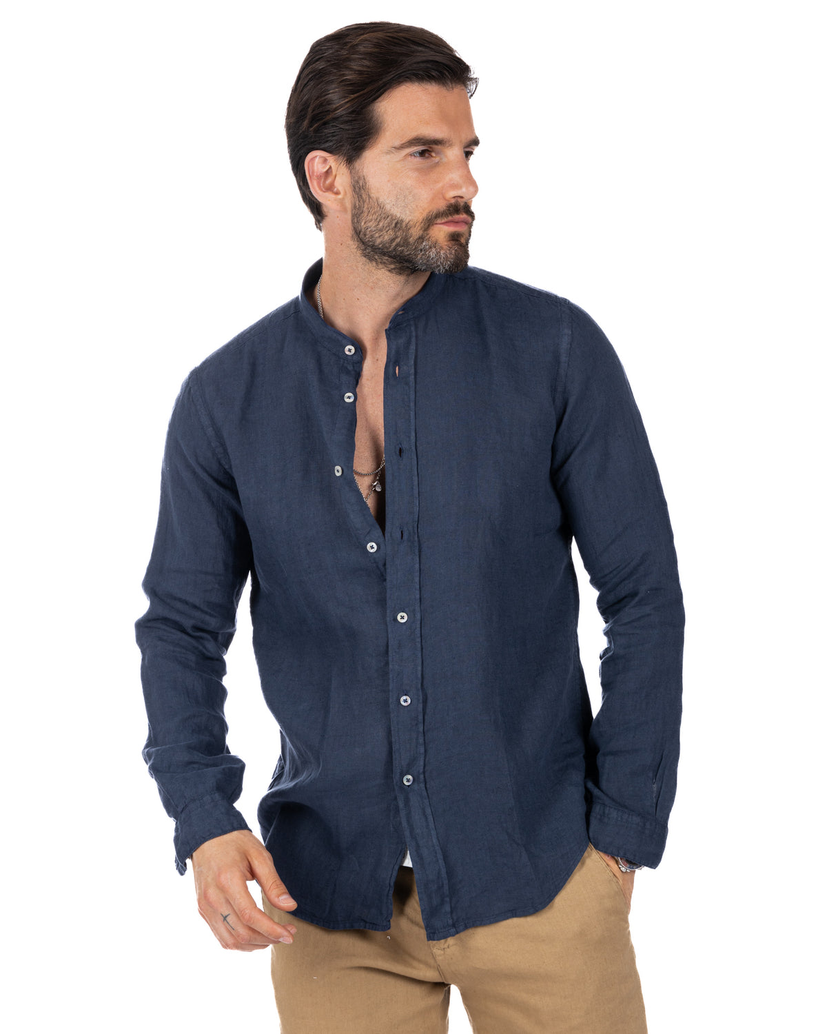 Navy blue linen long sleeve men's shirt with mandarin collar and button front, paired with tan pants.