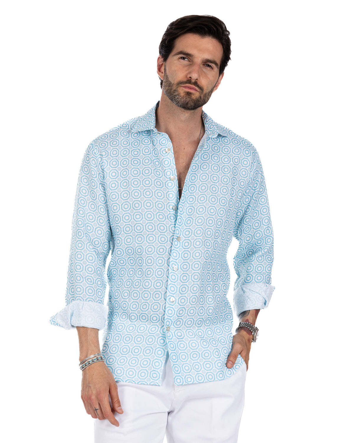 Light blue geometric print linen button-down shirt with rolled sleeves, paired with white pants.