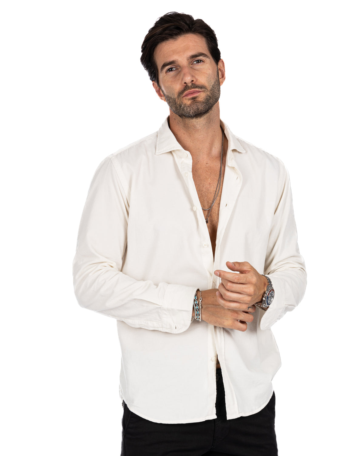 Men's white cotton long-sleeve button-down shirt with relaxed fit, worn open over black pants.