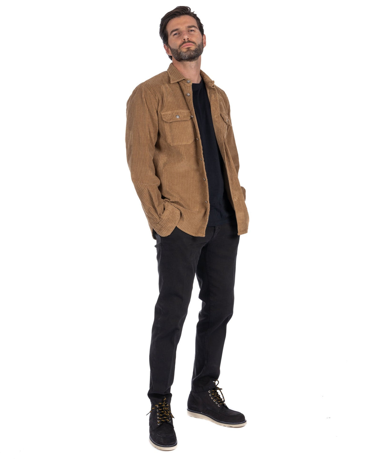 Men's tan corduroy button-up shirt jacket with chest pockets, styled with black pants and boots for casual fall fashion.