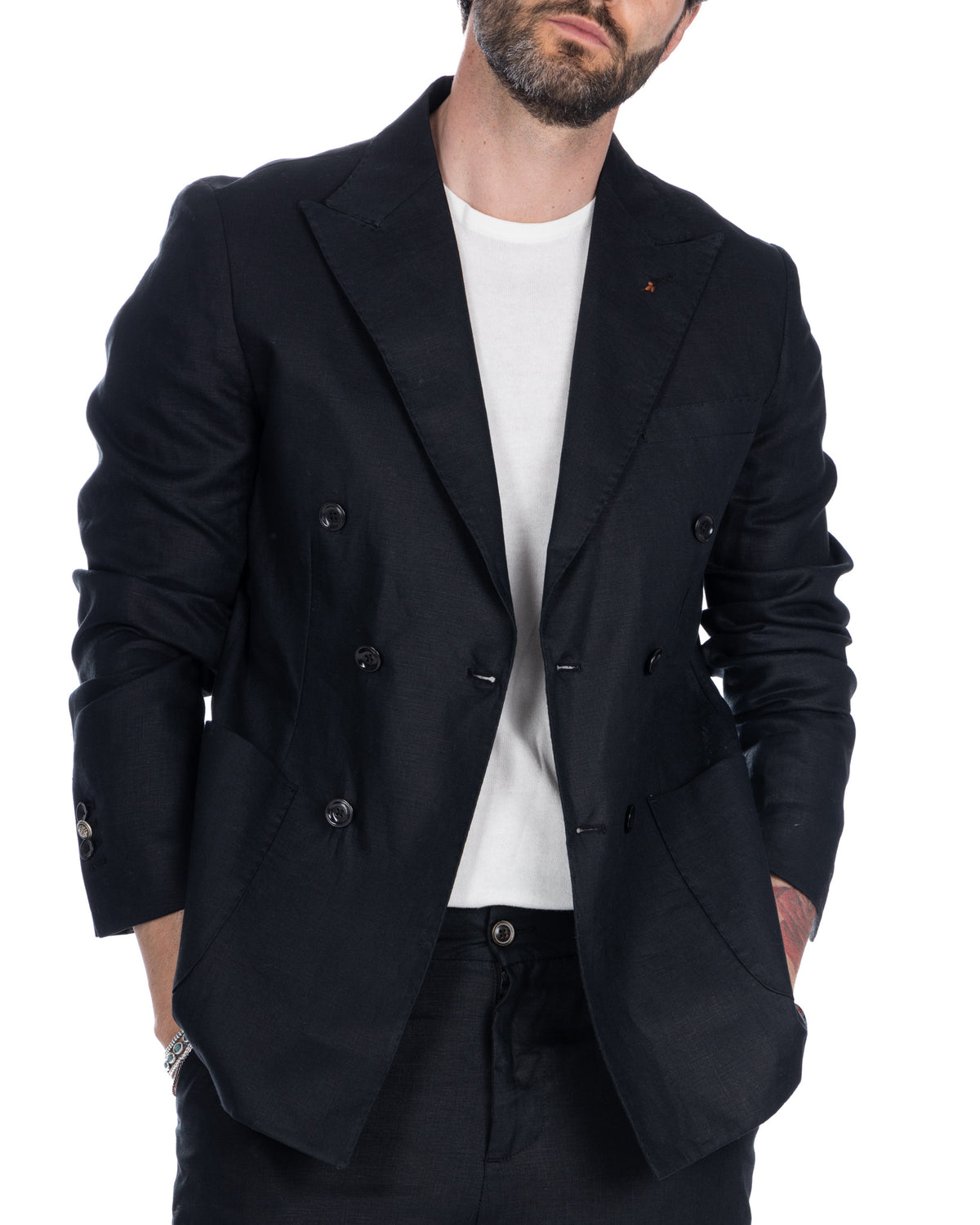 Black linen double-breasted blazer with peak lapels, worn open over white tee. Relaxed fit, unstructured shoulders.