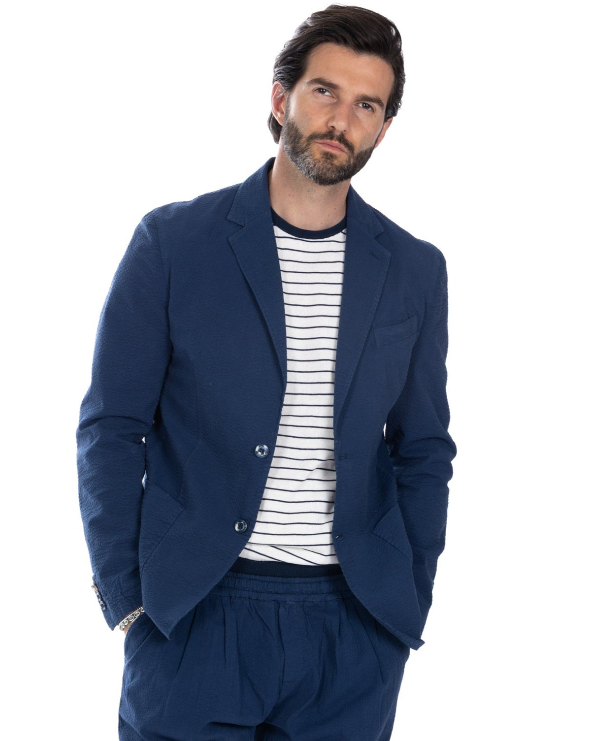 Navy blue textured blazer with striped tee. Casual tailored fit, two-button closure, relaxed style for men's fashion.
