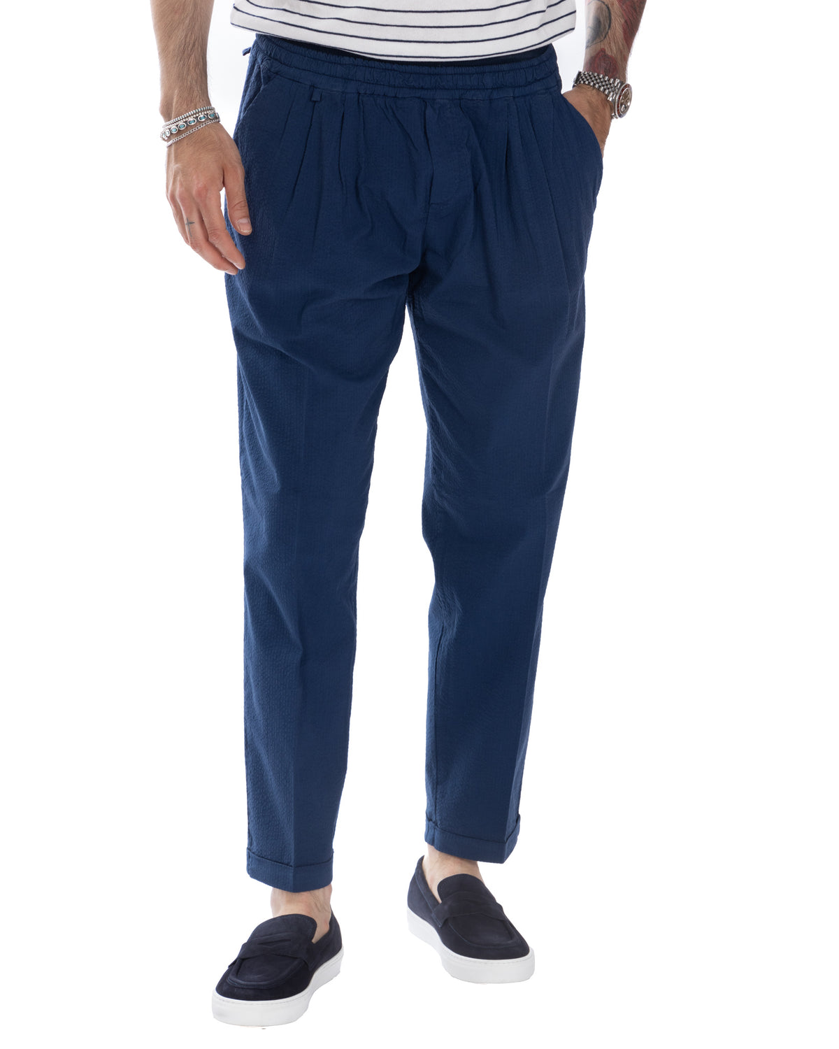 Navy blue pleated drawstring trousers with elastic waist, cuffed hem. Casual men's cotton pants in relaxed fit style.