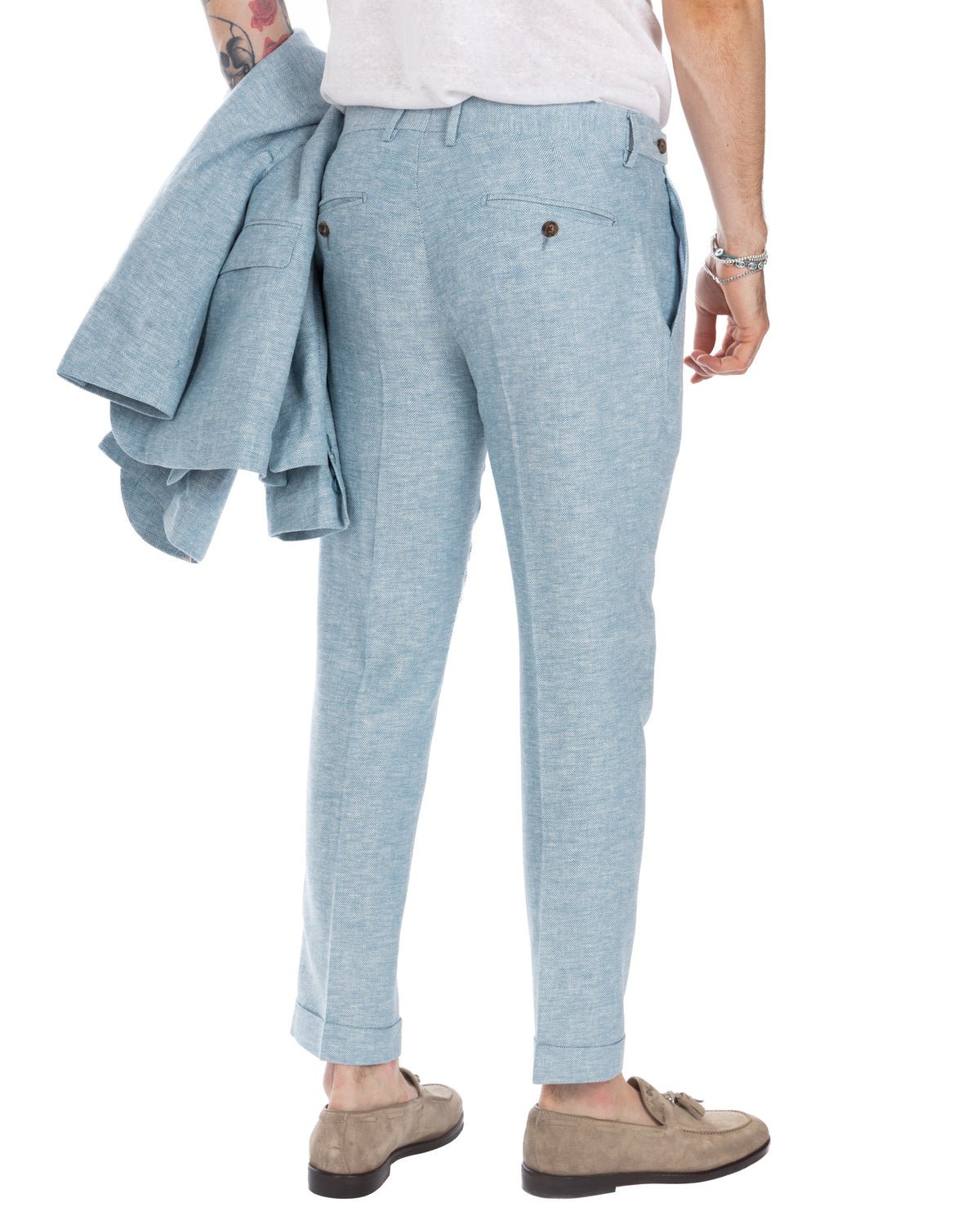 Light blue herringbone suit pants, slim fit with cuffed hem. Back view showing tailored cut and button pockets.