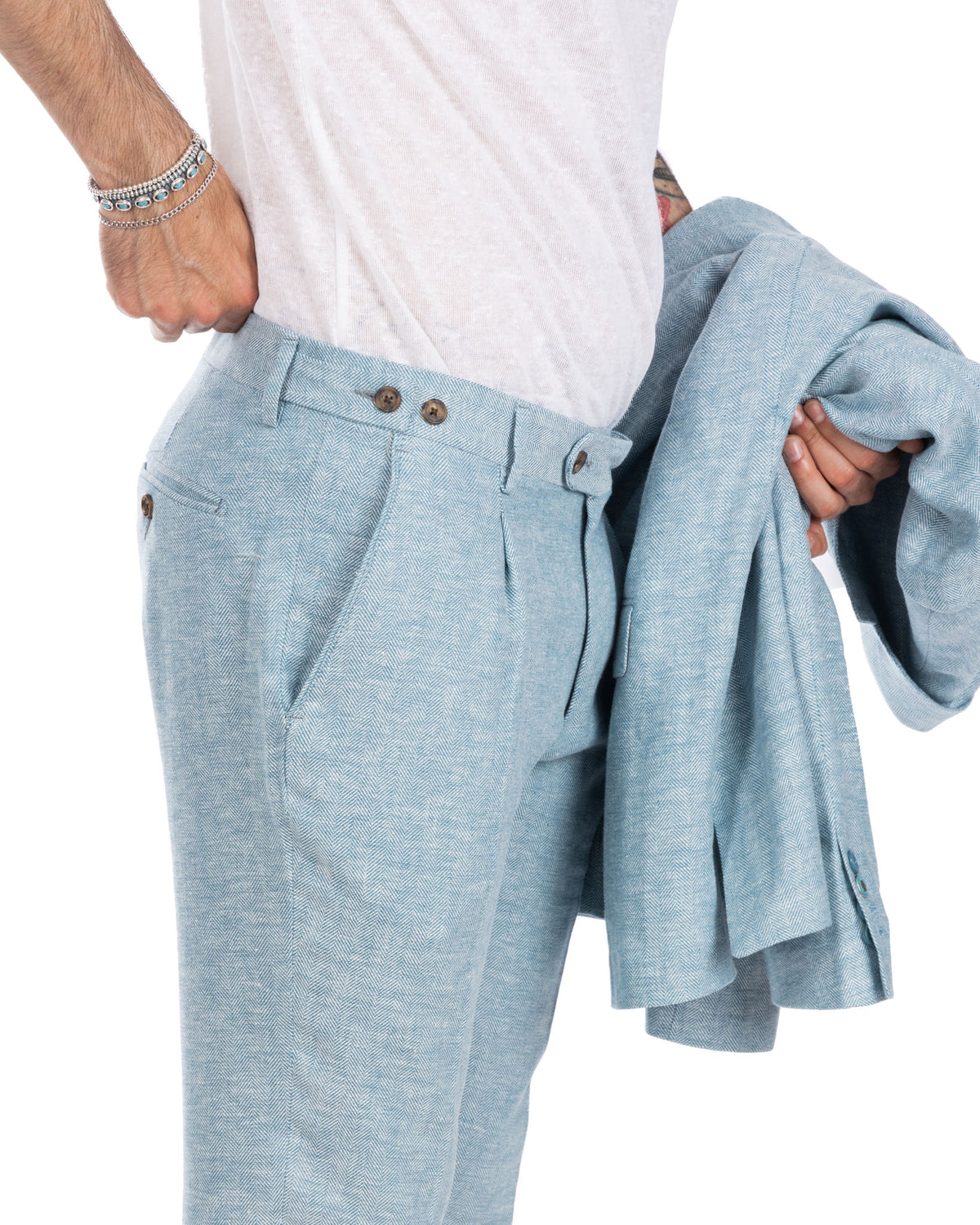 Light blue herringbone wool suit with pleated trousers, shown with white t-shirt. Tailored fit menswear separates.