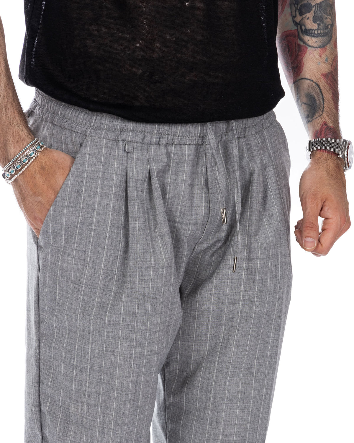 Gray pinstripe pleated trousers with elastic waist, drawstring detail. Men's relaxed fit dress pants in striped wool.