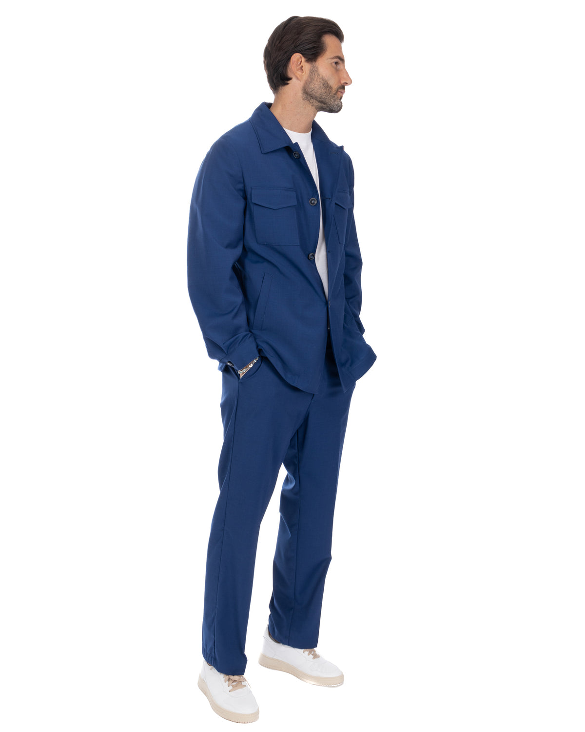 Men's navy blue cotton twill utility suit with button-front jacket, straight-leg pants, and white sneakers.
