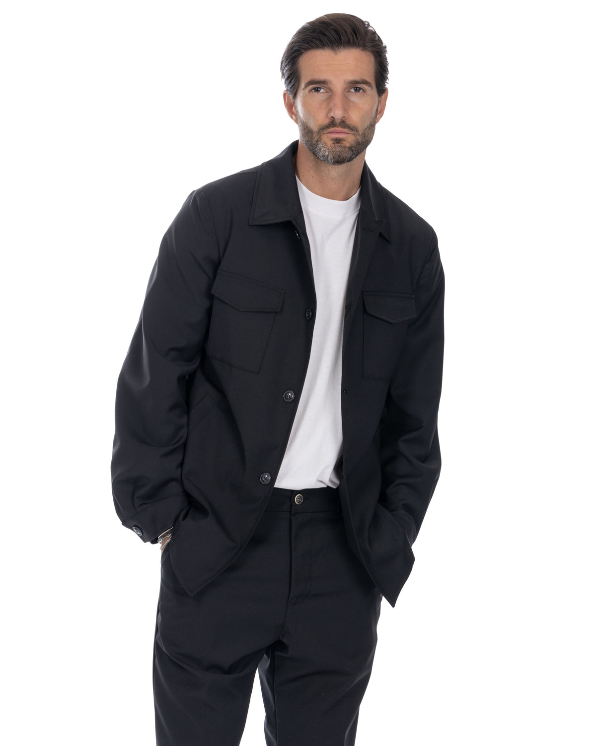 Black wool overshirt jacket with button front, chest pockets, and relaxed fit. Men's minimalist outerwear.