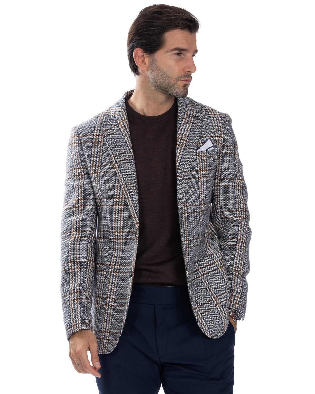 Men's grey plaid wool blazer with brown windowpane check, white pocket square, worn over dark sweater and navy trousers.