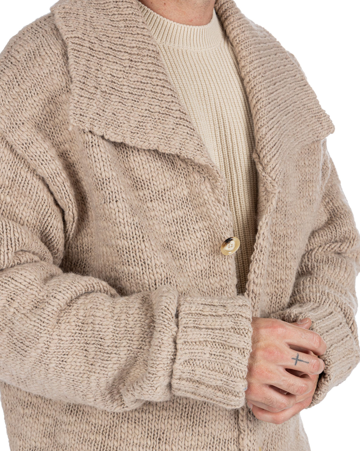 Beige chunky knit cardigan with shawl collar, horn button, and ribbed cuffs. Cozy wool-blend texture.