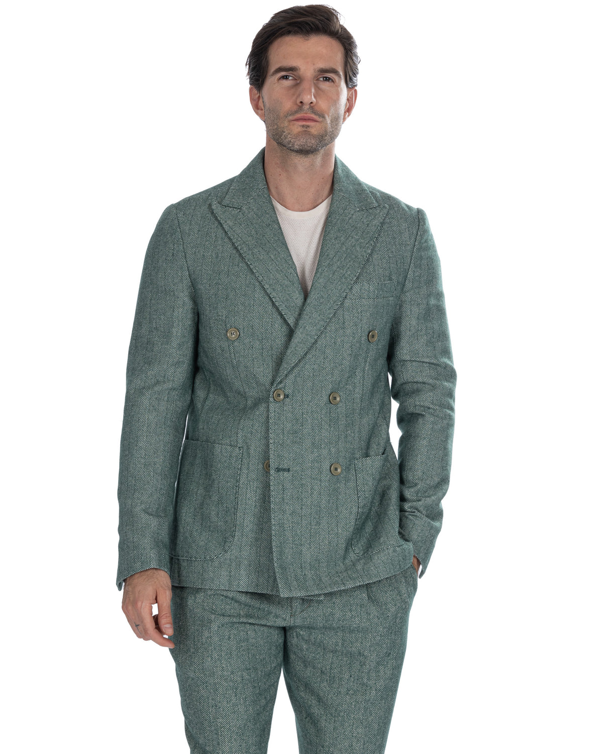 Green herringbone double-breasted wool suit with peak lapels and brass buttons, styled with cream knit.