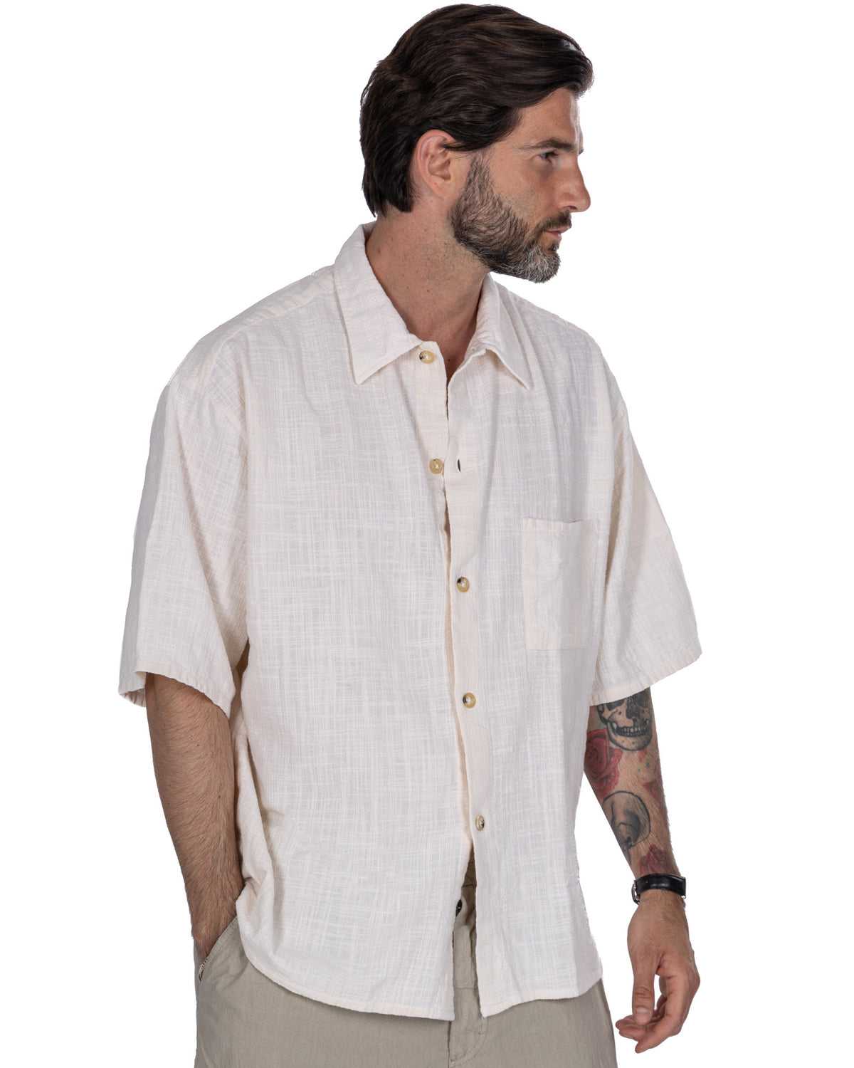 Men's cream linen short-sleeve button-up shirt with camp collar and chest pocket, relaxed summer style.