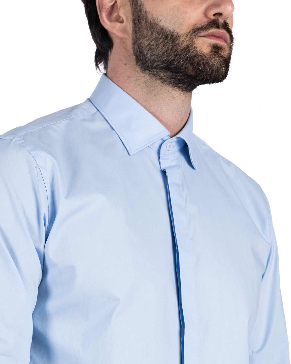 Close-up detail of a light blue cotton shirt collar and buttoned placket on a bearded model