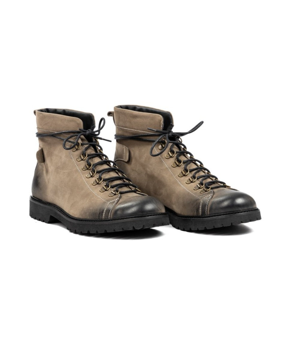 Taupe suede and black leather hiking boots with brass eyelets, black laces, and rugged rubber sole.