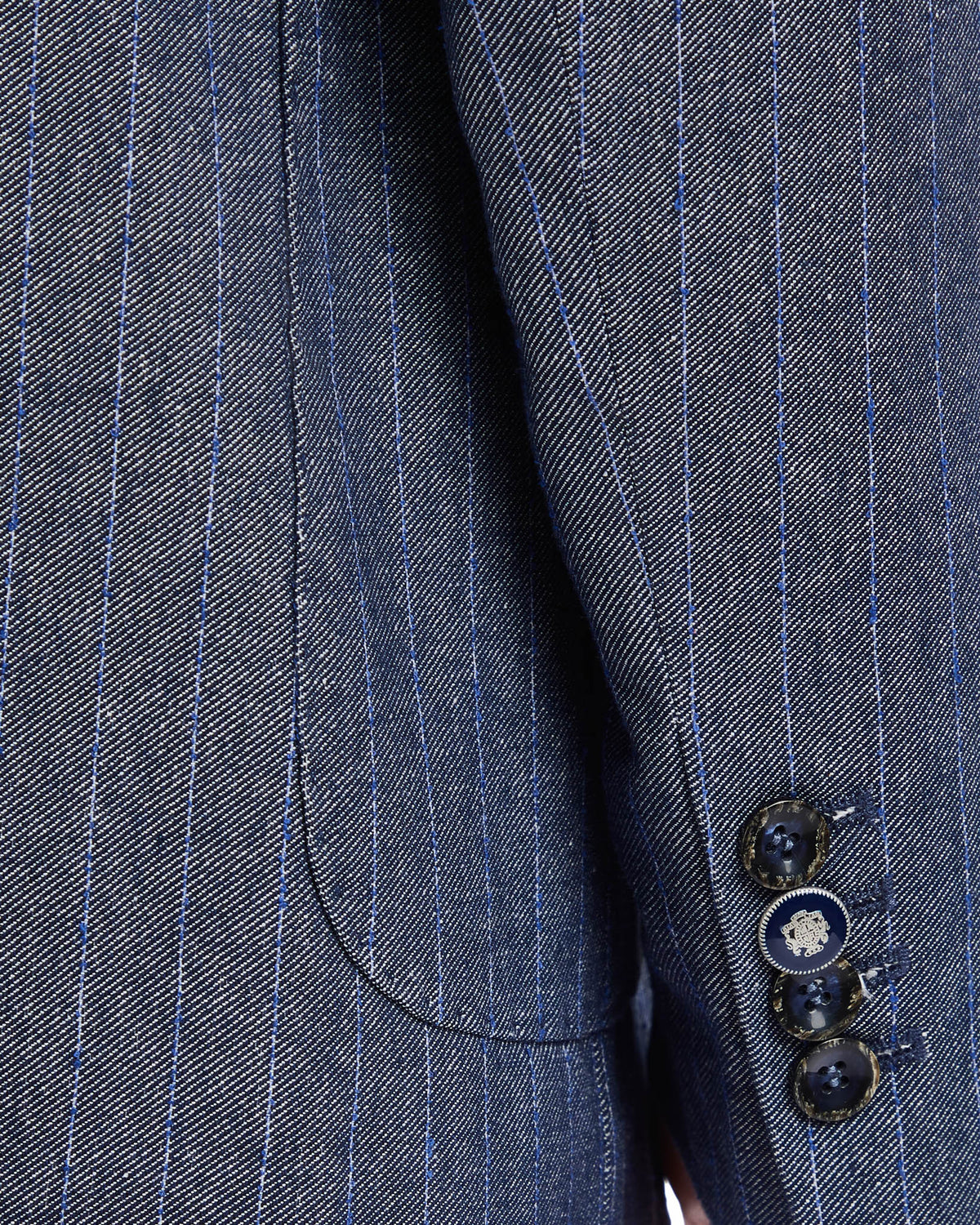 Blue pinstripe men's blazer sleeve with four-button cuff detail in textured fabric. Perfect for formal occasions.