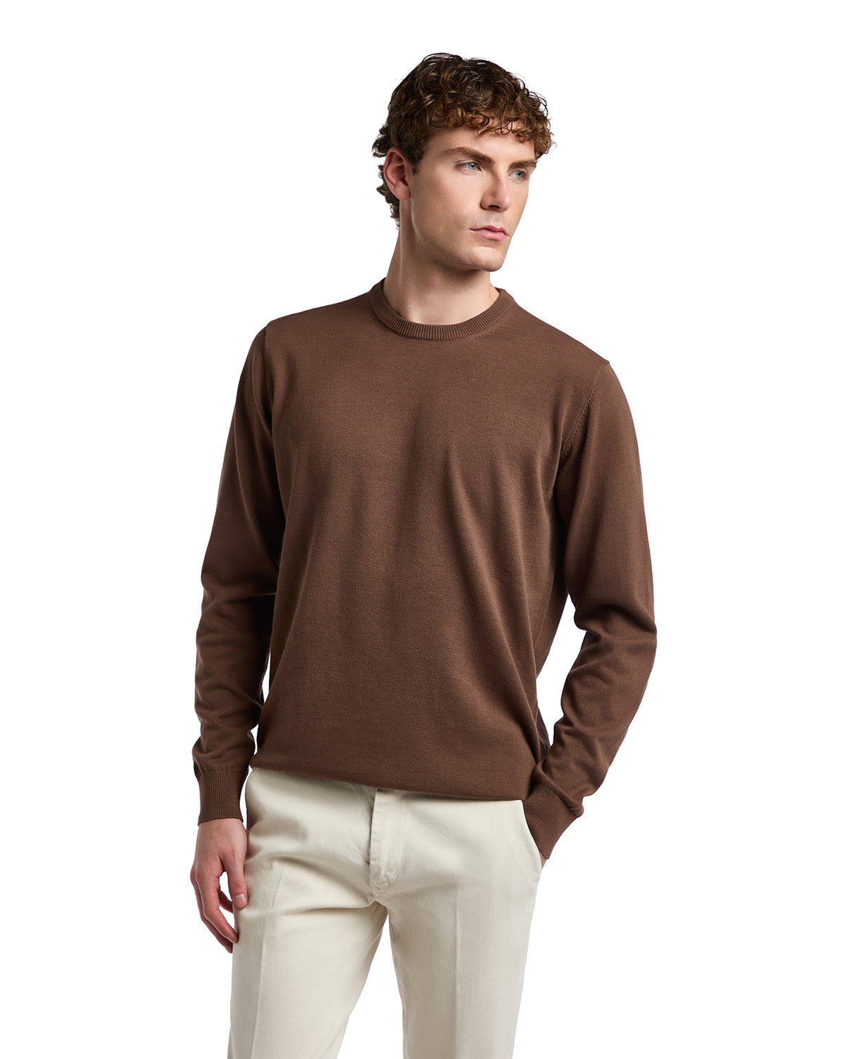 Men's brown crew neck sweater in soft knit, perfect for casual layering, paired with light trousers.