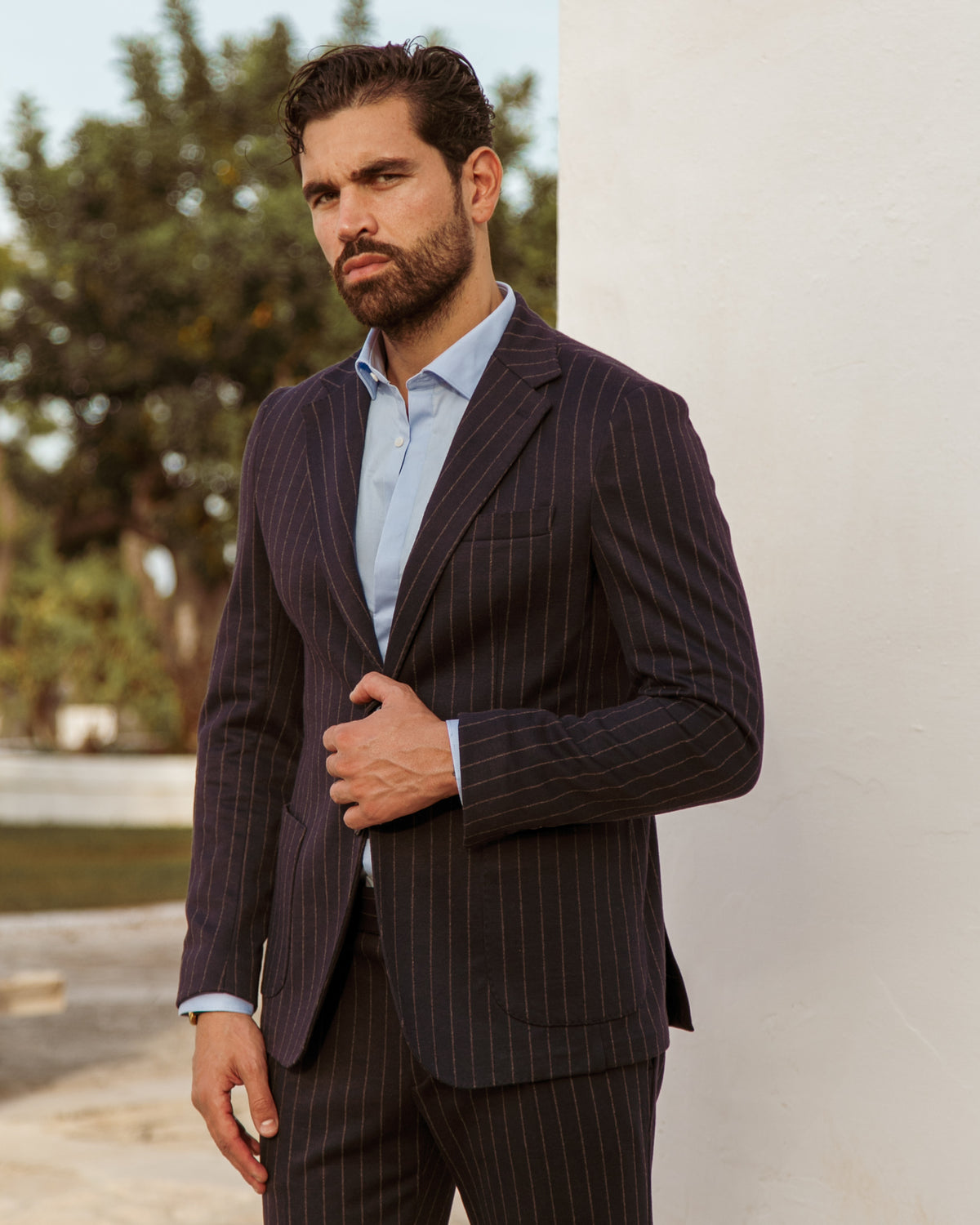 Navy pinstripe wool suit with light blue dress shirt, tailored fit, single-breasted blazer and matching trousers.
