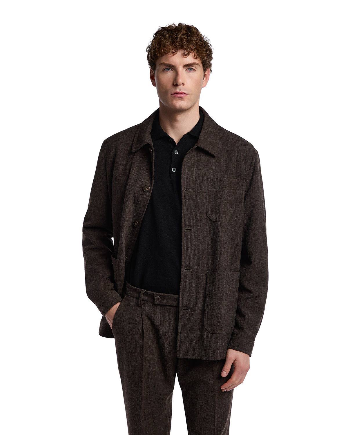 Brown wool blend jacket with a relaxed fit, front pockets, and button closure, paired with a black polo shirt.
