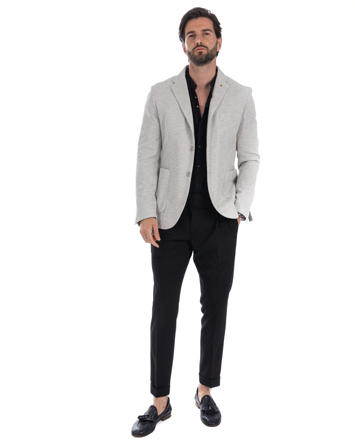 Light gray textured blazer with black shirt, slim black trousers, and black leather loafers. Smart casual men's fashion.