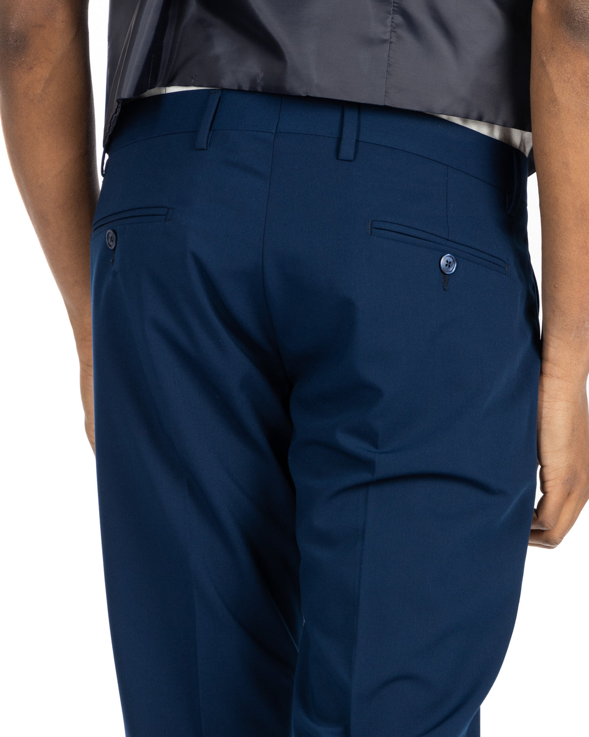 Navy blue slim-fit dress pants with buttoned back pockets, tailored wool-blend fabric for formal business wear.