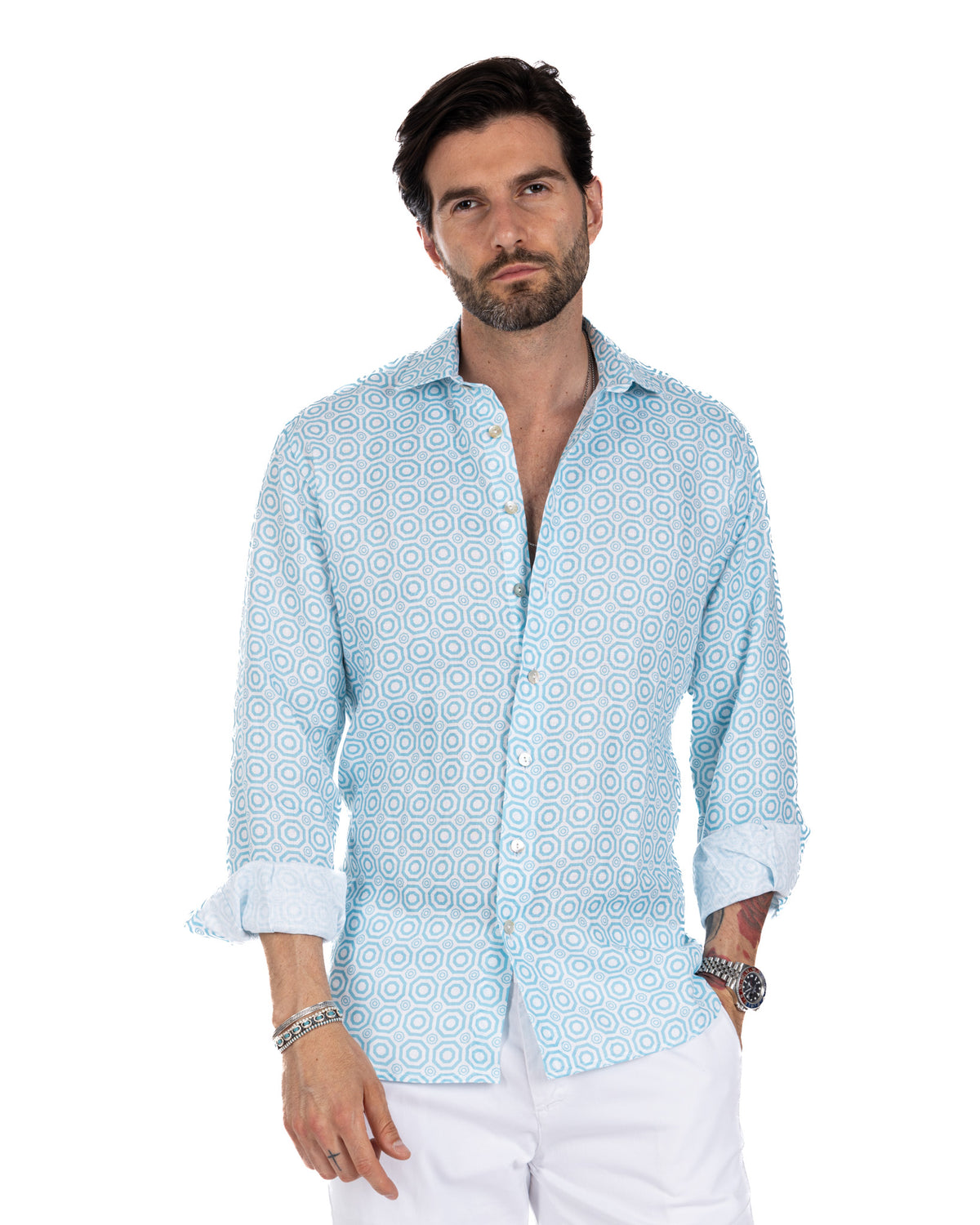 Light blue geometric print linen button-down shirt with rolled sleeves, paired with white pants.