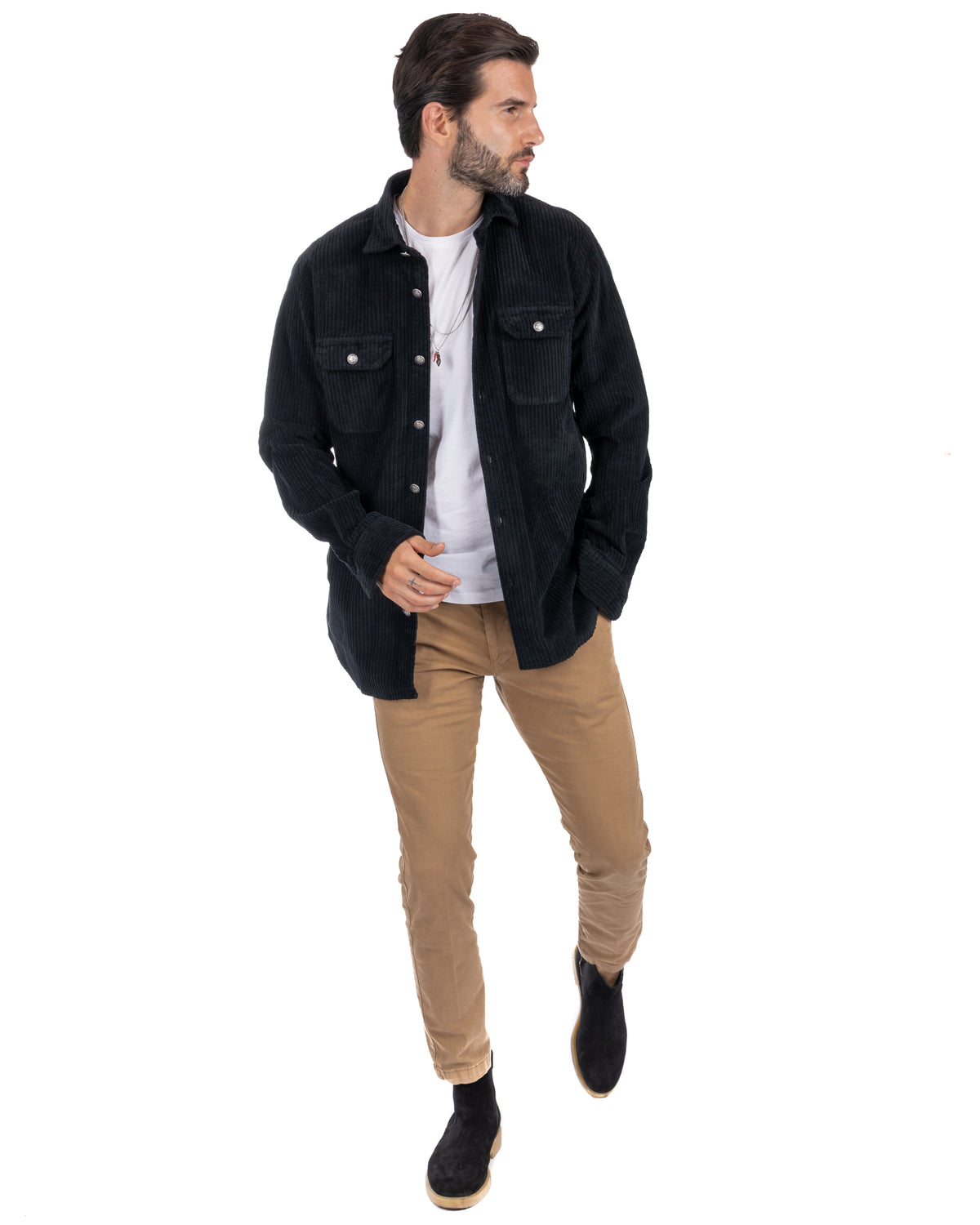 Men's black corduroy button-up shirt jacket with chest pockets, styled with tan chinos and suede Chelsea boots.