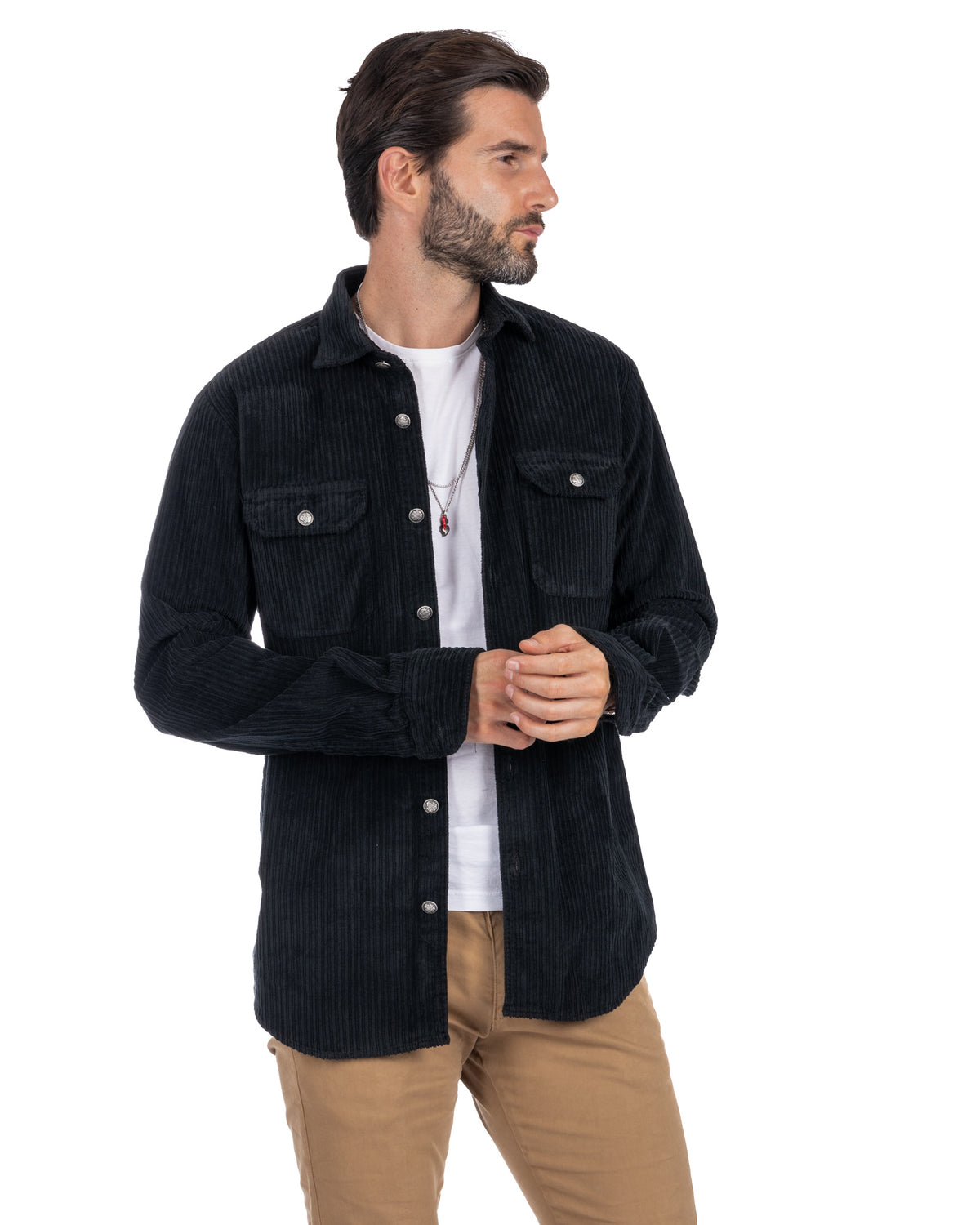 Men's black corduroy button-up shirt jacket with chest pockets, worn over white tee and tan pants.