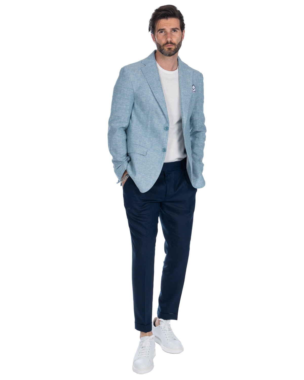 Light blue linen blazer with navy trousers, white t-shirt, and sneakers. Men's smart casual summer suit separate.
