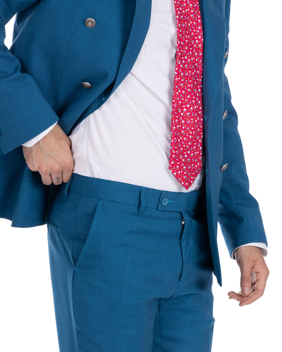 Teal blue slim fit suit with red floral tie, white dress shirt, and silver buttons. Modern formal menswear.