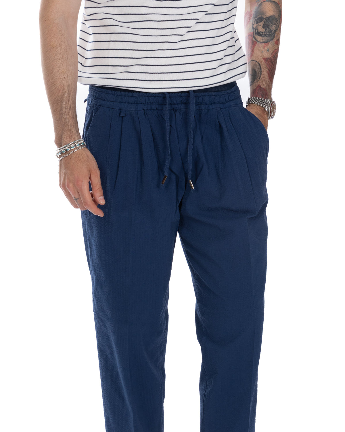 Navy blue relaxed fit drawstring pants with elastic waist, paired with striped top. Casual men's trousers.