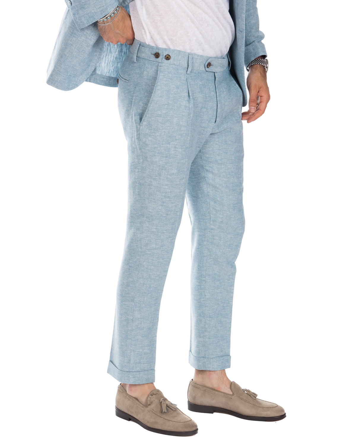 Light blue herringbone wool suit trousers with pleats, cuffed hem, and side adjusters. Tailored slim fit formal pants.