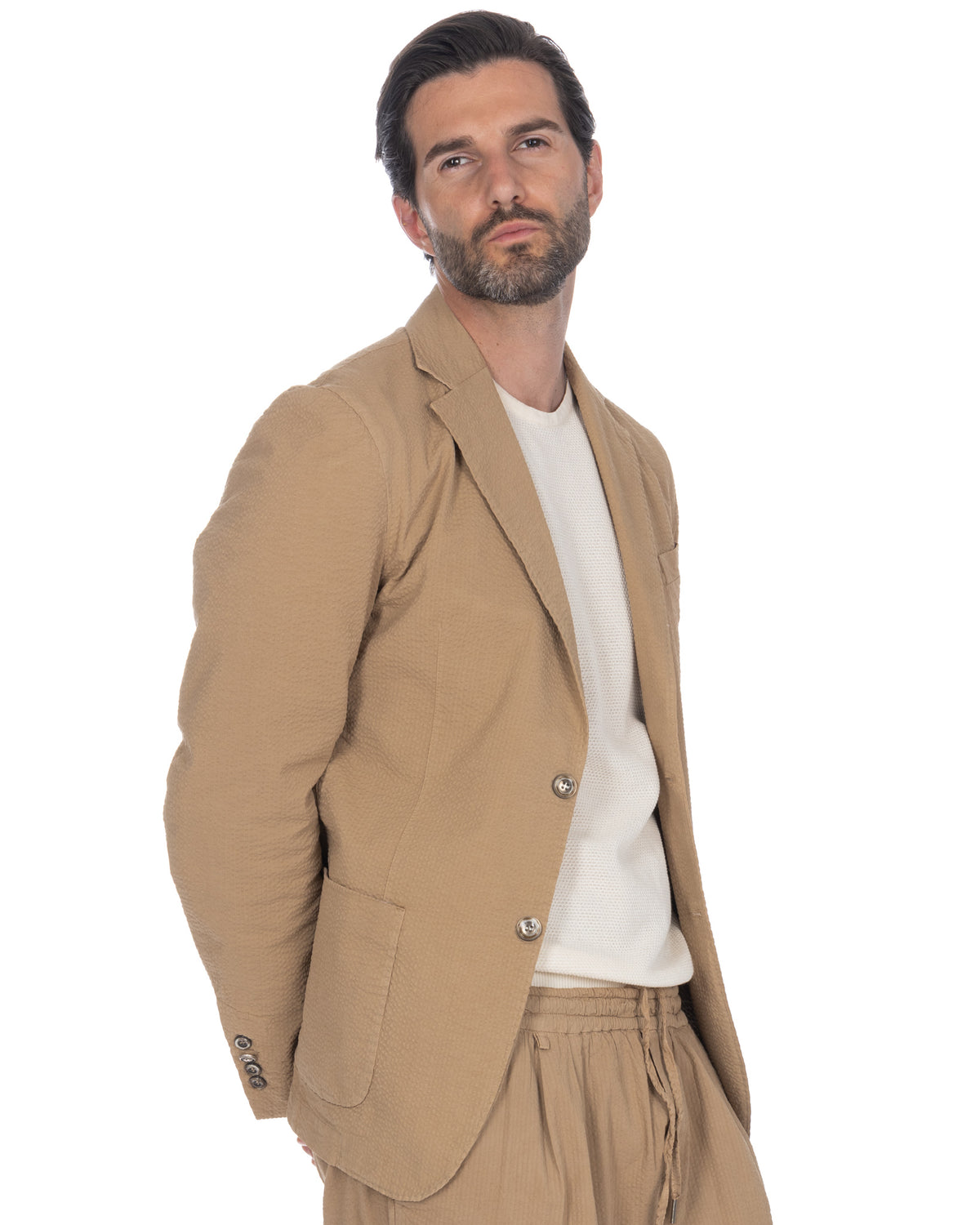 Men's beige seersucker unstructured blazer with notched lapels, two-button closure, and patch pockets.