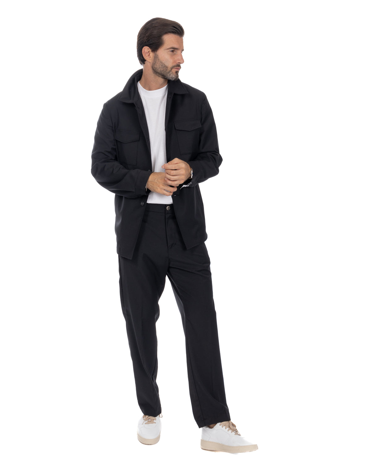 Man wearing black cotton utility jacket with matching trousers, white t-shirt, and white sneakers.