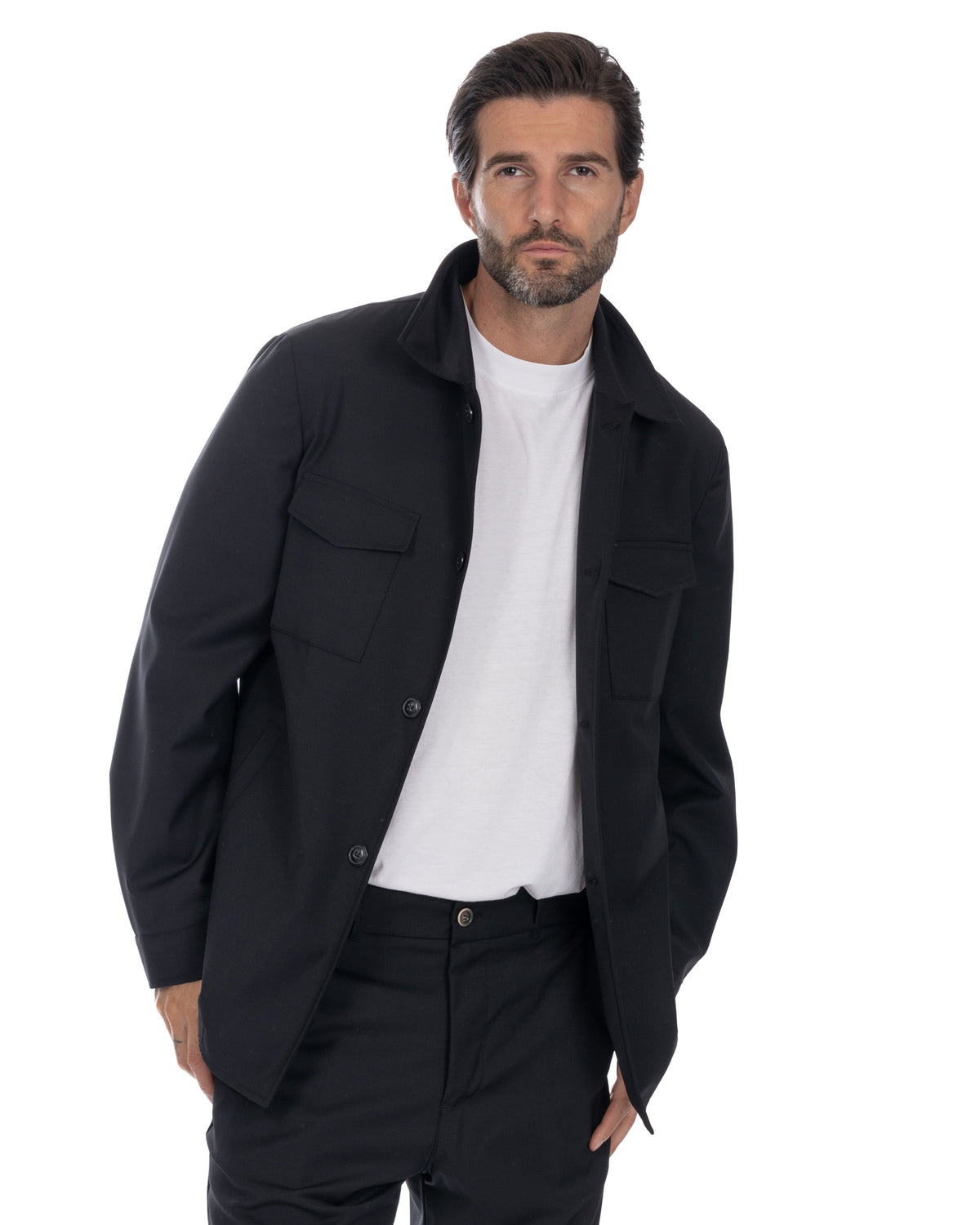 Black button-up shirt jacket with chest pockets, worn over white tee. Men's casual outerwear, solid color design.