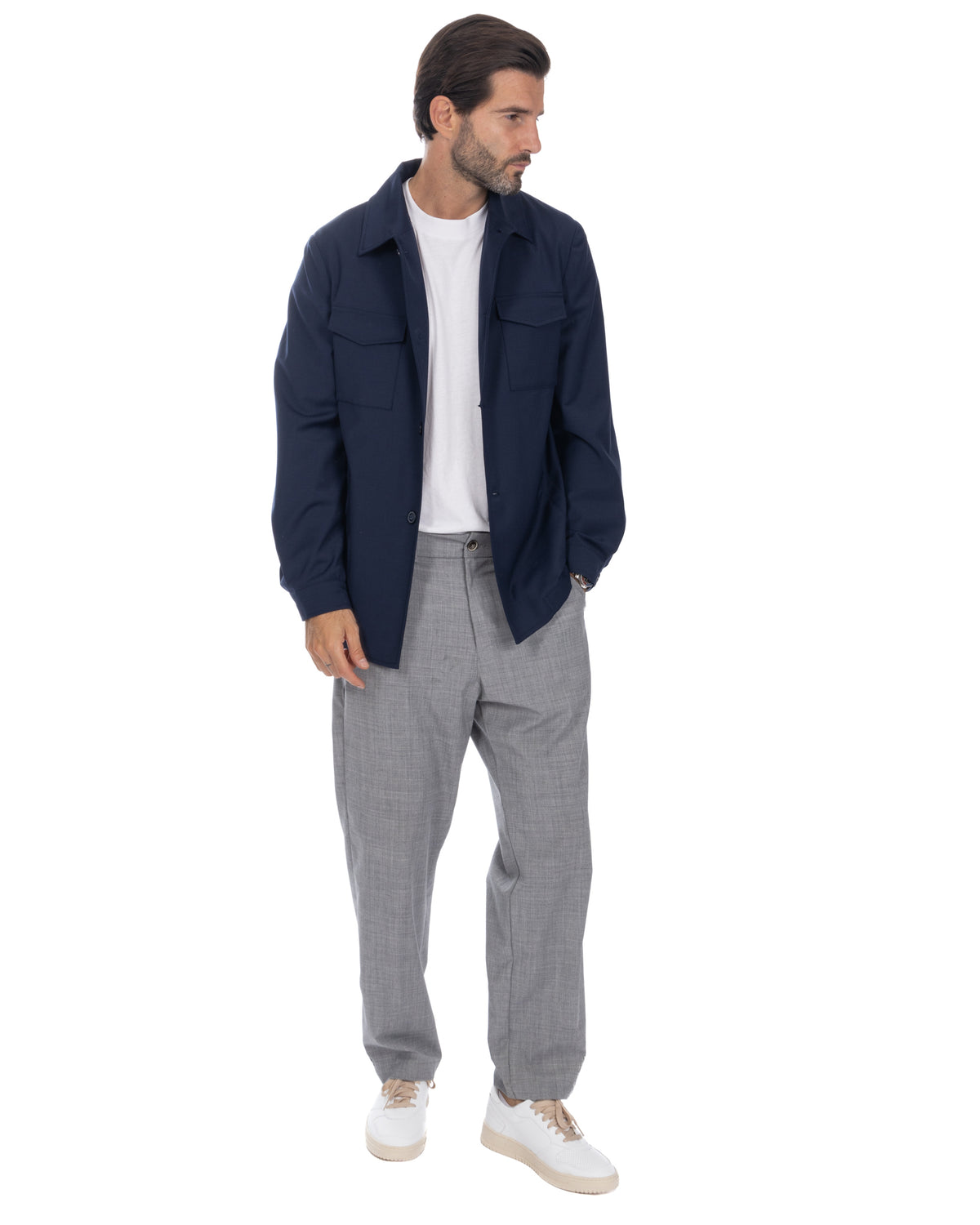 Navy wool overshirt jacket with chest pockets, paired with grey trousers and white sneakers. Men's smart casual outfit.