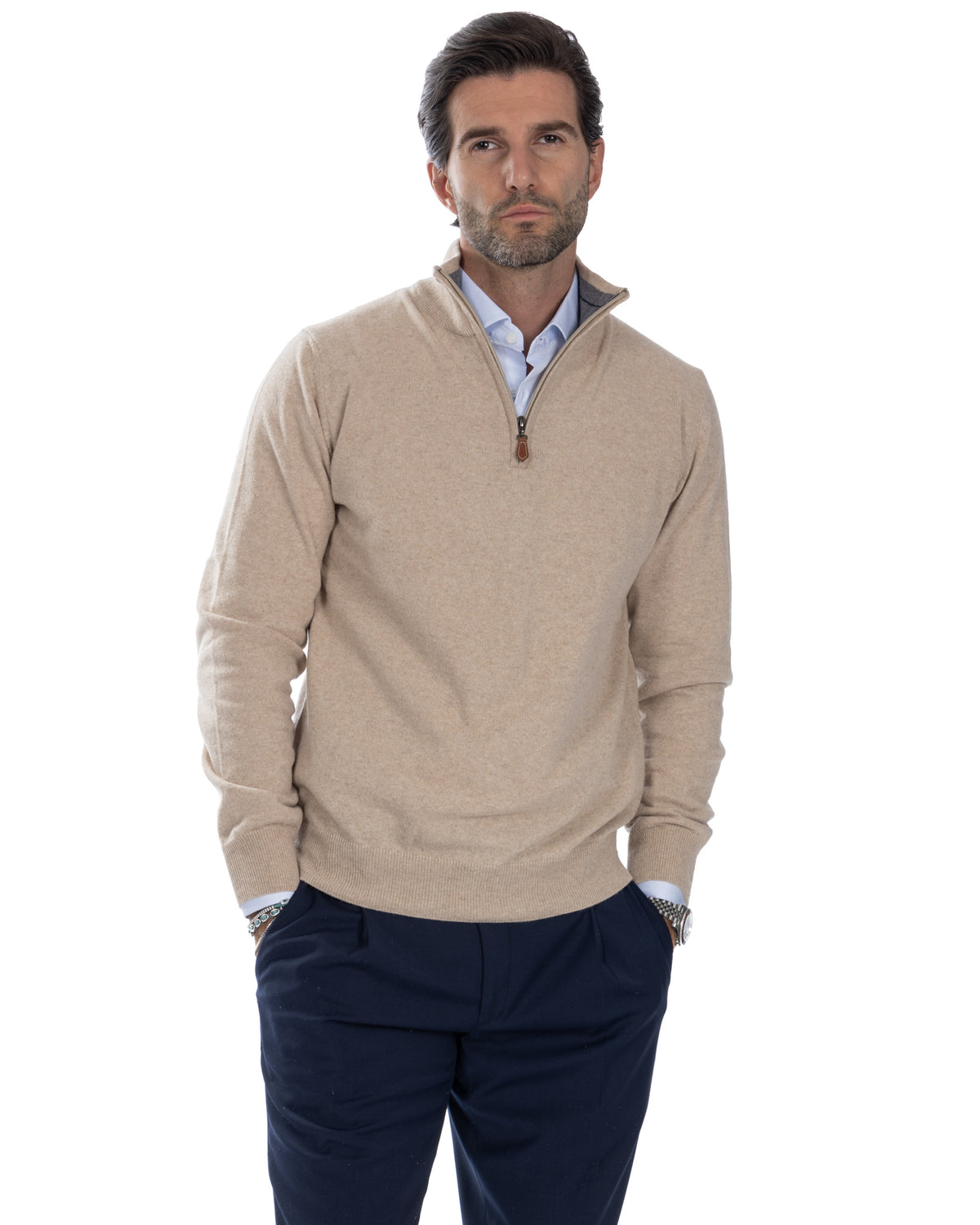 Men's beige cashmere quarter-zip sweater with mock neck, layered over light blue shirt and navy trousers.