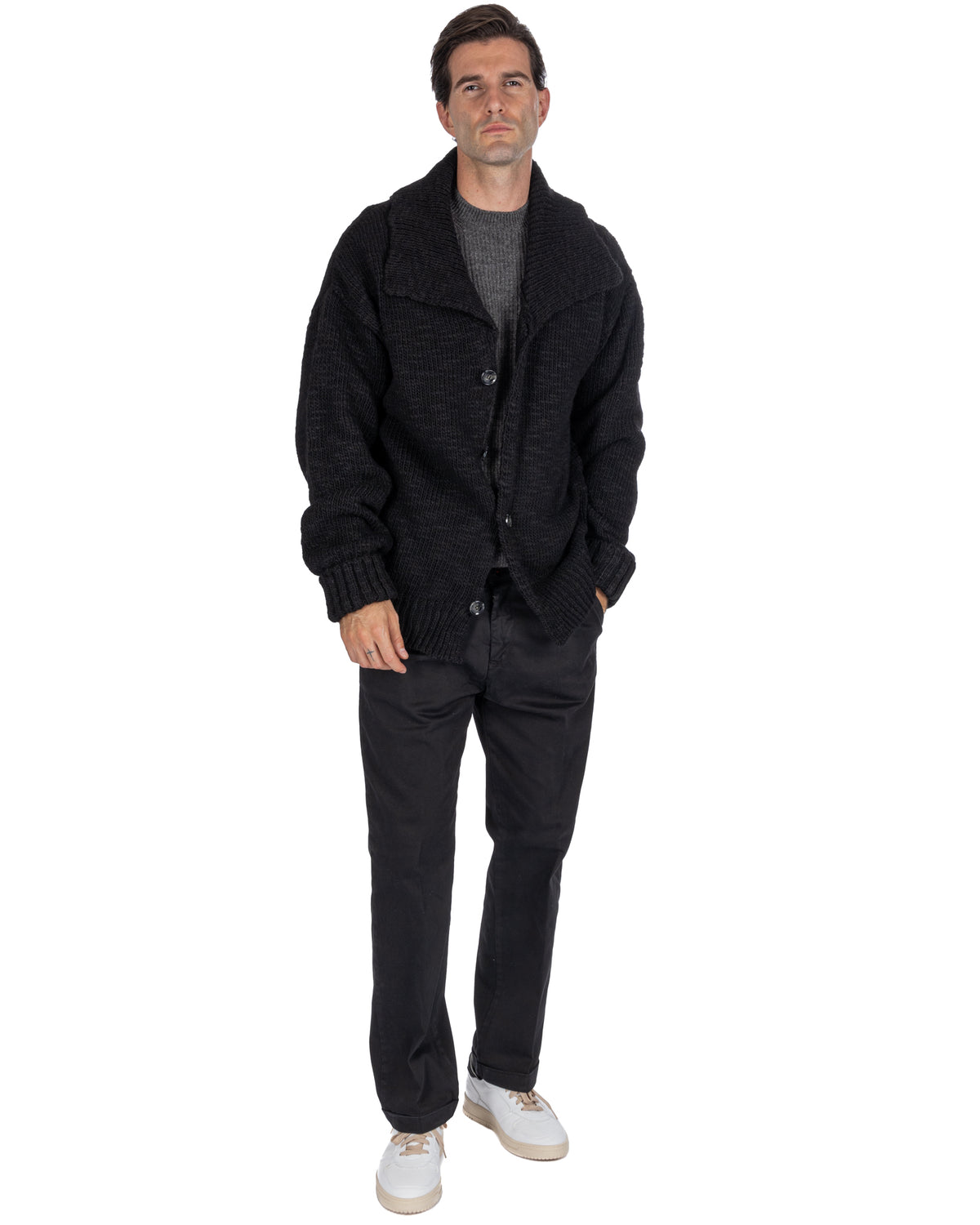 Black chunky knit wool cardigan with shawl collar, button front, and ribbed cuffs, styled with gray sweater.