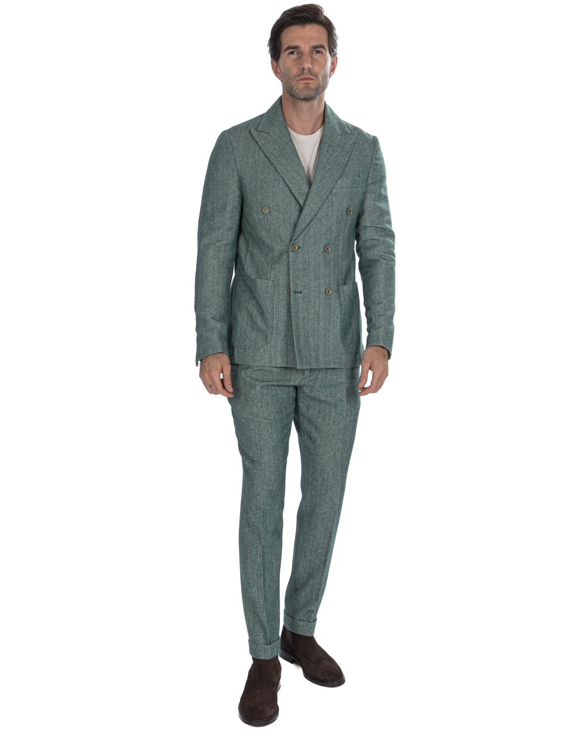 Green herringbone double-breasted suit with brass buttons, slim fit trousers, and brown suede shoes.