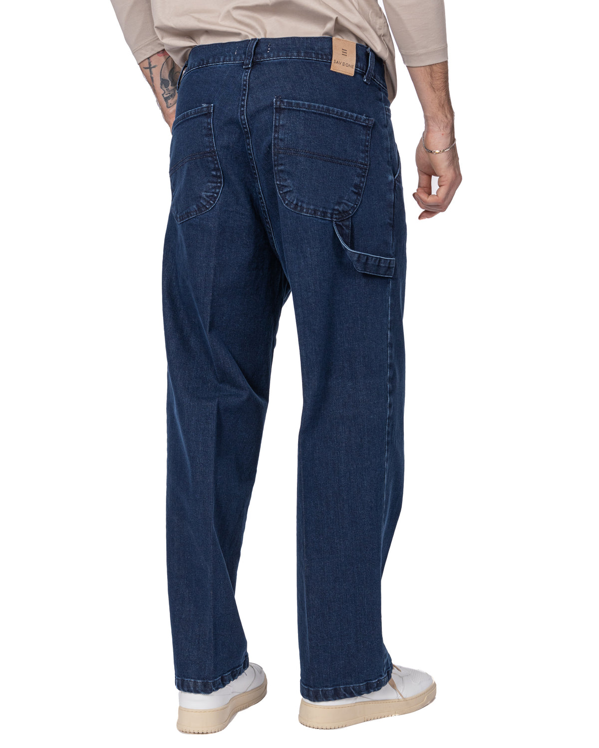 Dark blue denim carpenter jeans with utility pocket, straight leg fit, and leather brand tag on waistband.
