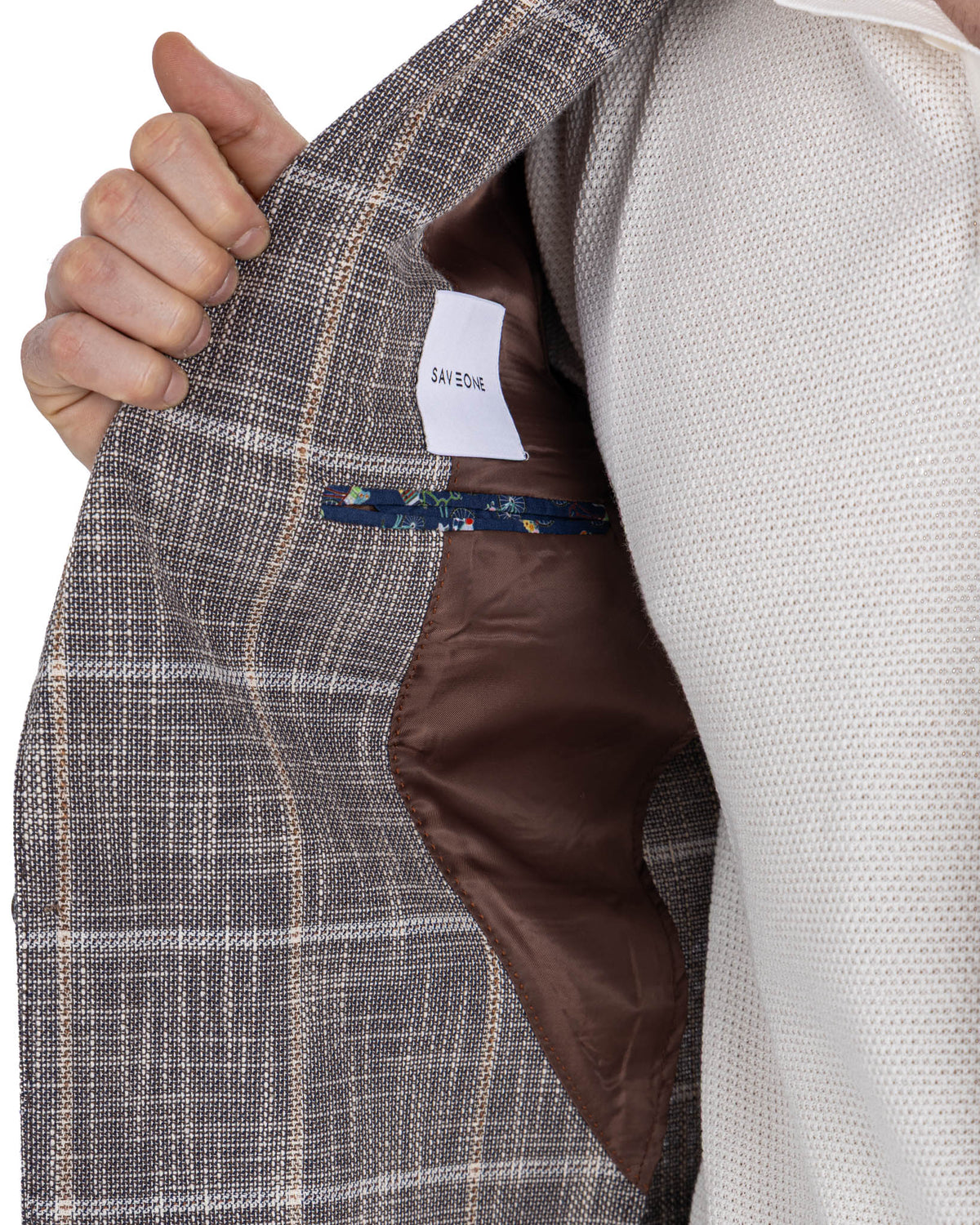 Brown plaid wool blazer interior with brown satin lining, floral pocket trim, and SAVONE brand label detail.