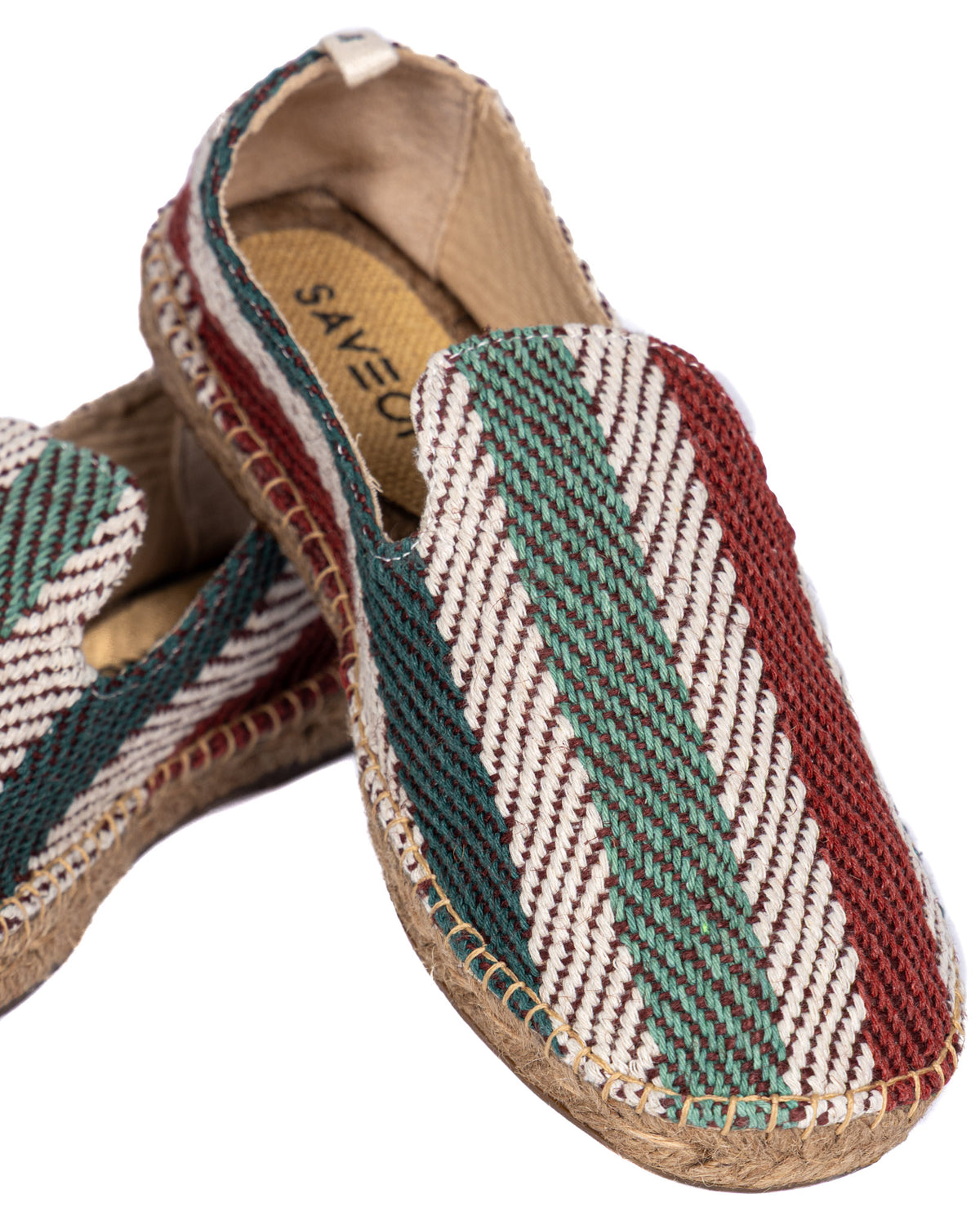 Woven espadrille slip-ons with green, red, and white tribal pattern, jute sole, and canvas lining.