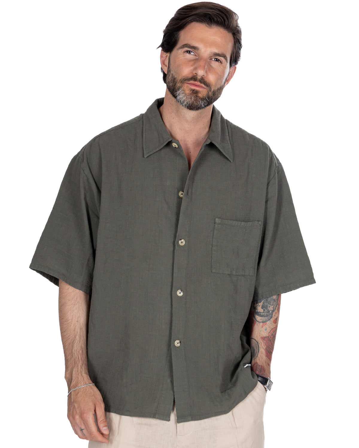Olive green short sleeve linen button-up shirt with relaxed fit, chest pocket, and camp collar.